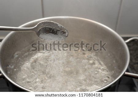 Putting salt in boiling water