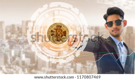 Bitcoin and cryptocurrency investing concept - Businessman pointing at Bitcoin with modern business building and cityscape in the background. Blockchain technology.