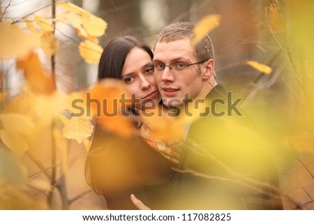 young lovers man and woman in the autumn forest