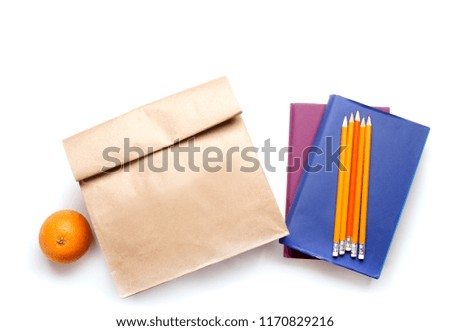 Lunch bag with orange and stationery on white background