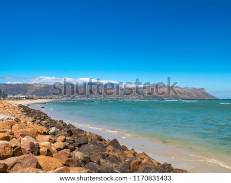 Beach scene, view east towards Gordons Bay and Hottentots-Holland Mountains. False Bay. The Strand. Western Cape. South Africa.