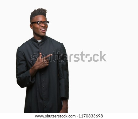 Young african american priest man over isolated background cheerful with a smile of face pointing with hand and finger up to the side with happy and natural expression on face looking at the camera.