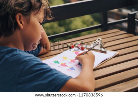Adorable kid drawing cute colourful picture.