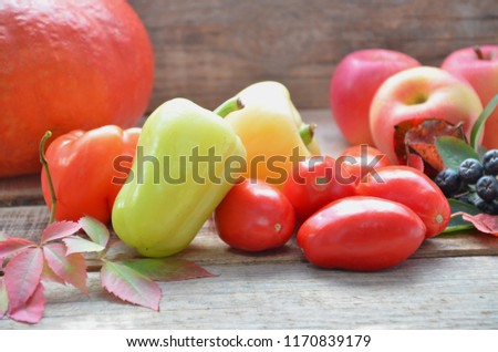Assortment of fresh fruits and vegetables. autumn harvesting vegetables - eggplant tomatoes zucchini sweet pepper, pumpkin. Autumn leaves on a wooden background