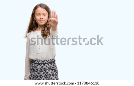Brunette hispanic girl doing stop sing with palm of the hand. Warning expression with negative and serious gesture on the face.
