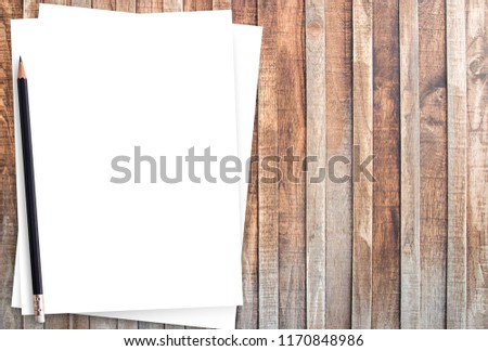 White paper and pencil on old wooden background. Blank paper on wooden background or texture. Abstract wood background, empty template space for design
