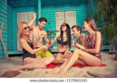 Group of five friends celebrating in their summer beach house