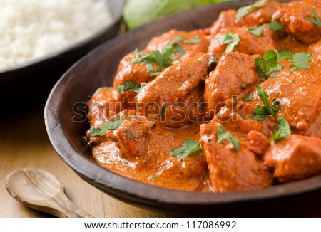 Butter chicken curry with basmati rice and limes. Royalty-Free Stock Photo #117086992