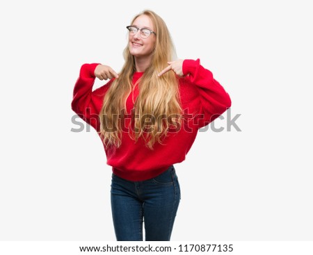Blonde teenager woman wearing red sweater looking confident with smile on face, pointing oneself with fingers proud and happy.