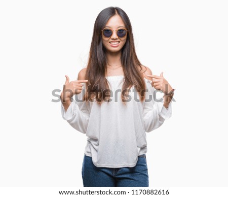 Young asian woman wearing sunglasses over isolated background looking confident with smile on face, pointing oneself with fingers proud and happy.