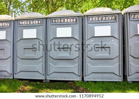 Rows of fiberglass reinforced polymer mobile toilet cabins in a park