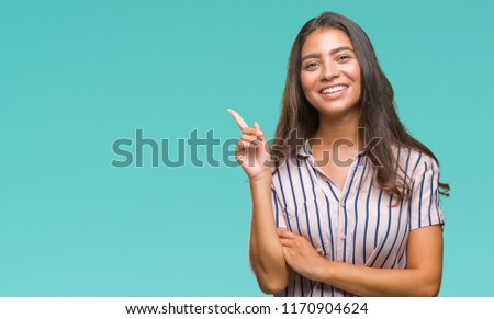Young beautiful arab woman over isolated background with a big smile on face, pointing with hand and finger to the side looking at the camera.