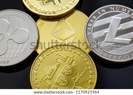 Stack of Bitcoins, Ethereum, Litecoin, Ripple and other crypto currencies on a table.