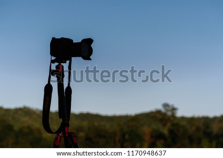 silhouette camera on tripod in neture background
