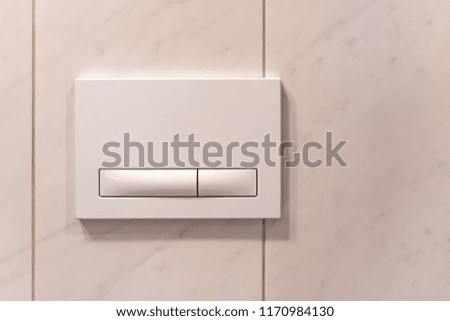 Generic white switch with two different buttons, screwed to the wall, soft focus with copy space