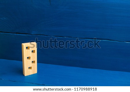 Apartments and apartments. Minimalism. for presentations. Wooden figure of a multi-storey house on a blue background. Three-story house. Buying and selling of real estate, construction.