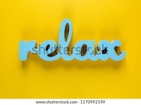 Relax - inspirational word with wooden letters at bright yellow background, typography for poster, t-shirt or card. flat lay, copyspace