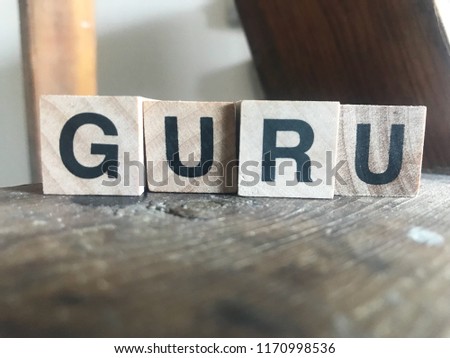 Word Guru written with wood cubes in close up