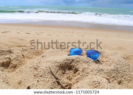 blue sunglasses isolated on beach background