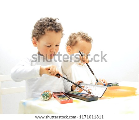 Easter eggs with boys decorating and painting the egg with white background with people stock photo