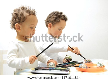 Easter eggs with boys decorating and painting the egg with white background with people stock photo