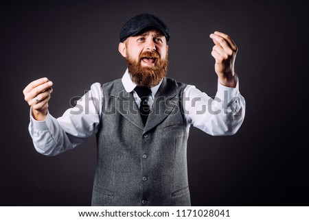 A bearded man in suit talking and gesticulating like italian on black background Royalty-Free Stock Photo #1171028041