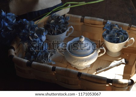 
Vintage basket, old cups, old key hydrangea flowers and a hat