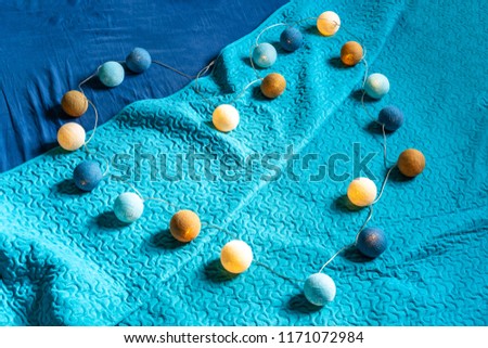 Christmas Decoration Light Balls Laying on Mattress with Turquoise Background, Heart Shape