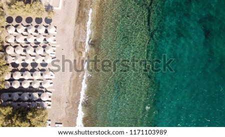 Aerial bird's eye view photo taken by drone of tropical seascape and rocky beach with turquoise clear waters and sunbeds