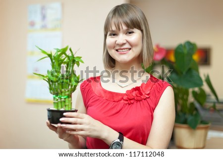 Girl with lucky bamboo plant at her home