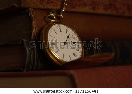 vintage pocket watch on a stack of books.