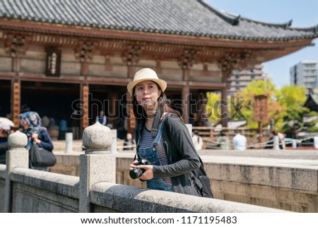 beautiful asian woman taking a photo on the bridge in the famous traditional temple in japan.