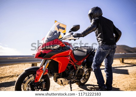 Rider Standing Next To His Motorcycle On a California Highway