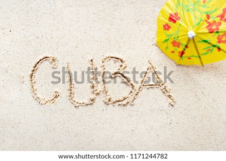 Handwriting words "Cuba" on sand of beach
