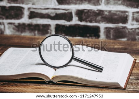 Book and magnifying glass