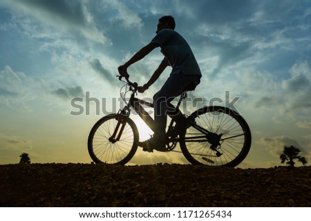 Cyclist on a country road,Men Happy cyclist riding on a mountain bike outside, Adventure travel,Men cyclist. Mountain bike,healthy lifestyle,Silhouette,