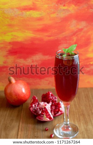 Glass of fresh pomegranate juice with fruit with colorful background