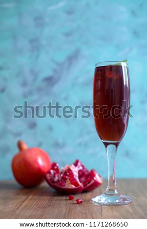 Pomegranate juice in a glass with rustic blue background