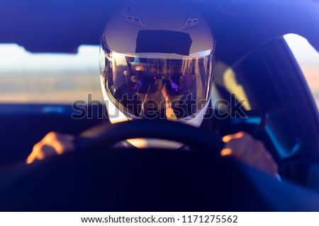 A Helmeted Race Car Driver At The Wheel Royalty-Free Stock Photo #1171275562