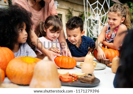Young kids carving Halloween jack-o&#39;-lanterns