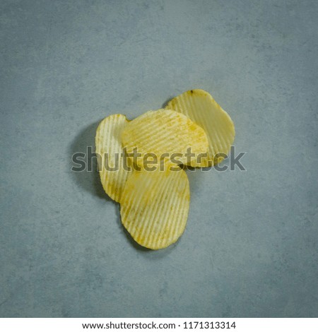 Top view of pile potato chips on dark background