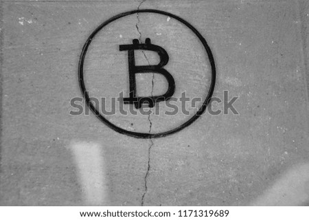 Bitcoin on glass with wall background. Black and white picture.