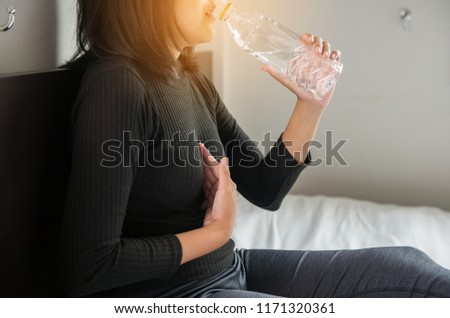 Asian woman drinking water having or symptomatic reflux acids,Gastroesophageal reflux disease Royalty-Free Stock Photo #1171320361