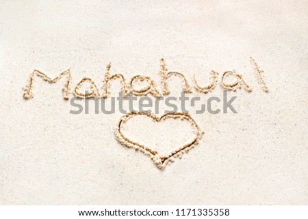 Handwriting words "Mahahual" on sand of beach