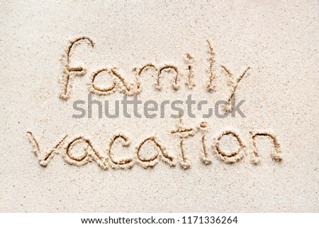 Handwriting words "Family Vacation" on sand of beach