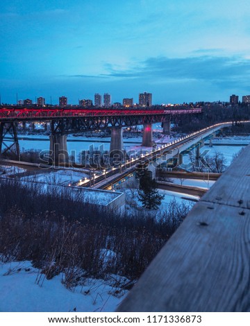 A picture of the High Level Bridge next to the LRT bridge located in Edmonton, Alberta, Canada. Colourful lights make the High Level quite the sight, especially when driving through it.