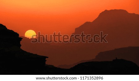 Scenic landscape of sunset above the silhouettes of mountains