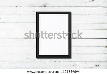 White poster Or a white picture frame hanging on the white wood wall background in the room.Have space for your message.