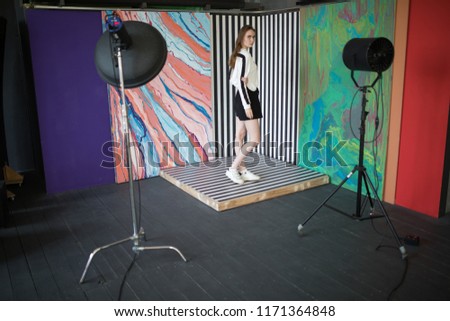 Model posing in a professional photo studio on a bright background.