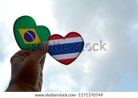 Hand holds a heart Shape Brazil and Thailand flag, love between two countries